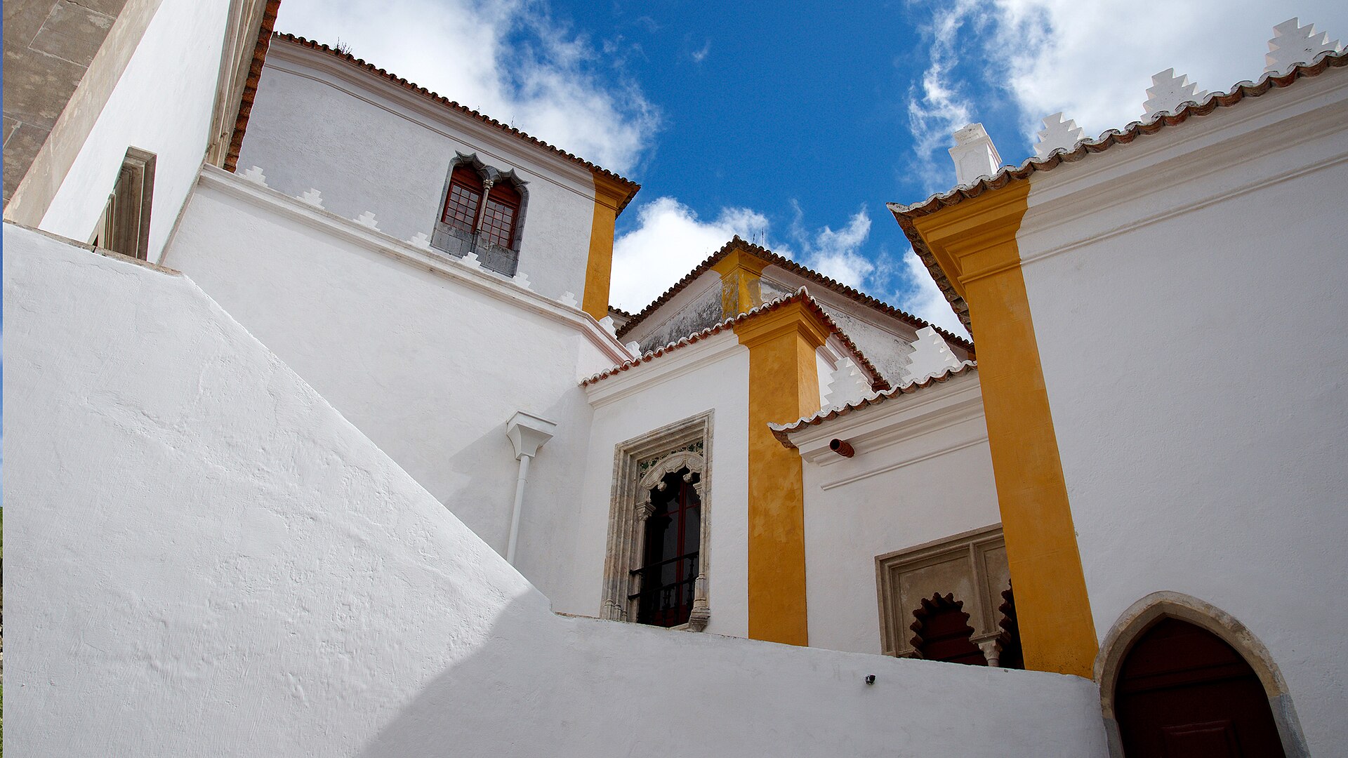 White walls, yellow trim and carved stone windows at Sintra’s National Palace